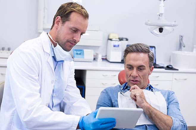 allowing-for-healthy-oral-development-dentist-check-up-report-discuss-with-old-man