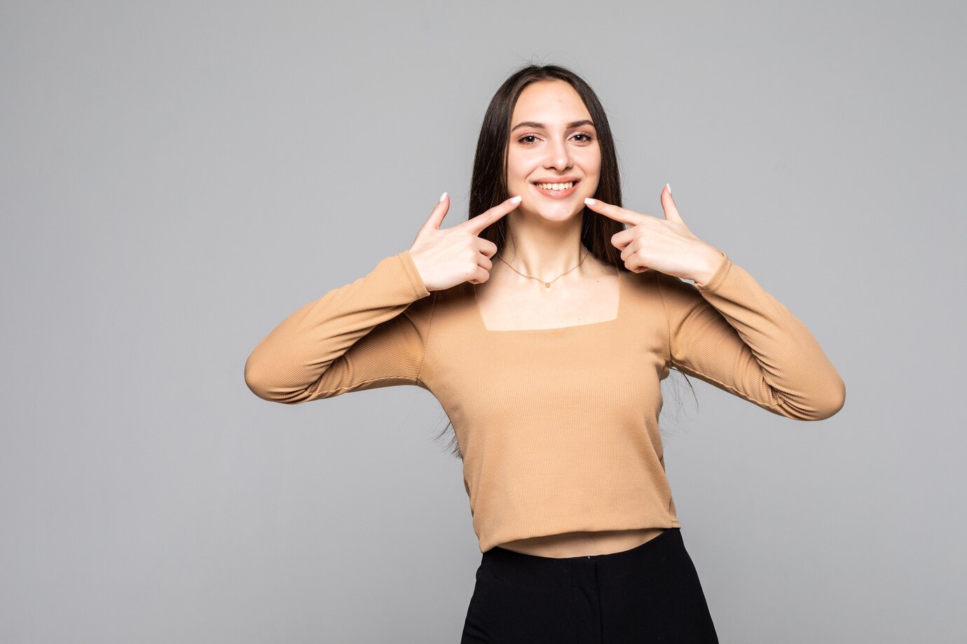 clean-healthy-teeth-young-smiling-beautiful-woman-i-points-fingers-her-teeth-gray-wall-isolated_231208-12934