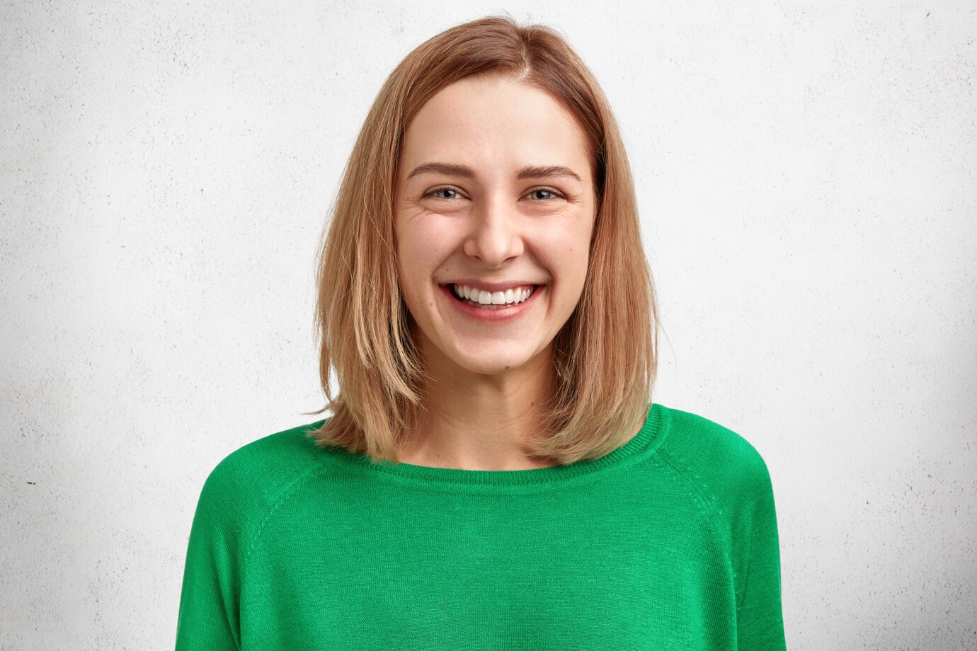 horizontal-portrait-beautiful-cheerful-young-female-model-with-bobbed-hairstyle-pleasant-gentle-smile-healthy-skin-wears-green-sweater_273609-3528