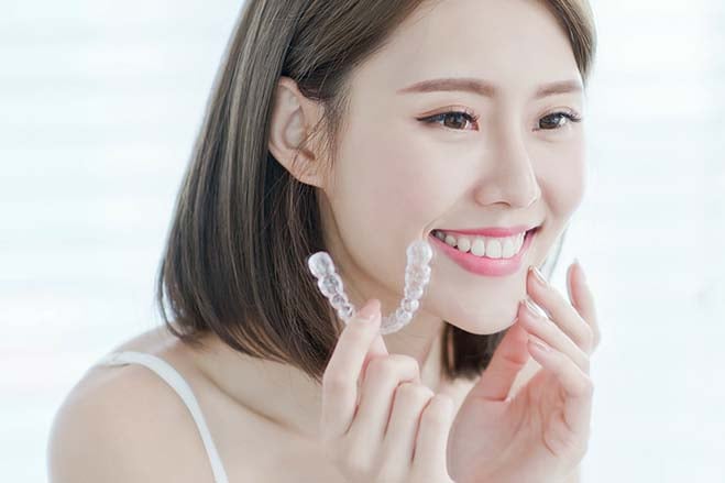 simple-to-use-pretty-asian-girl-holding-invisalign-dental-care-oral-health