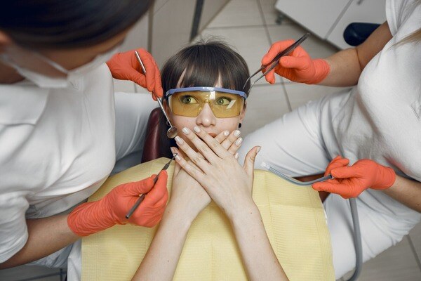 woman-dental-chair-girl-covers-her-mouth-dentists-treat-girl-s-teeth_1157-40920 (1)