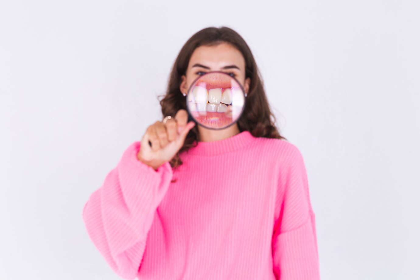 young-beautiful-woman-with-freckles-light-makeup-sweater-white-wall-with-magnifier-shows-white-teeth-perfect-smile_343596-6982