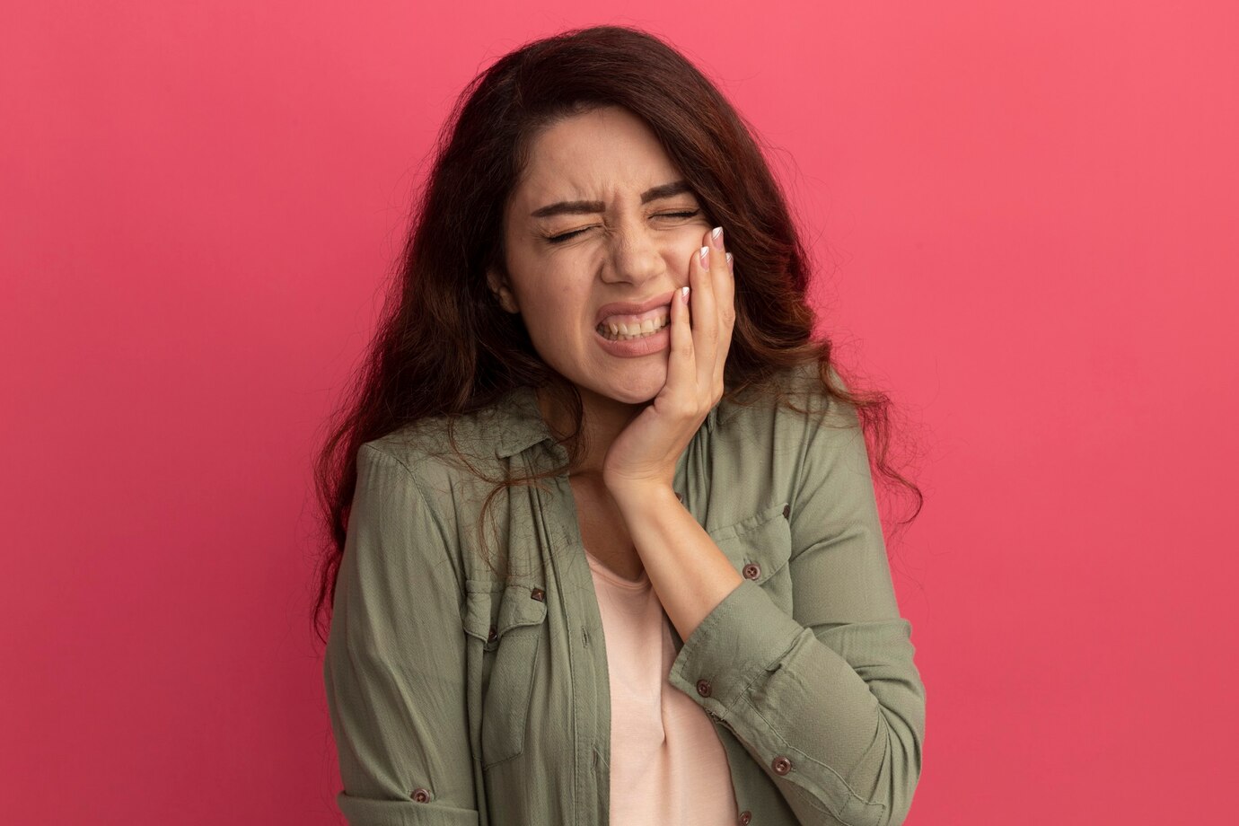 aching-young-beautiful-girl-wearing-olive-green-t-shirt-putting-hand-aching-tooth-isolated-pink-wall_141793-83055