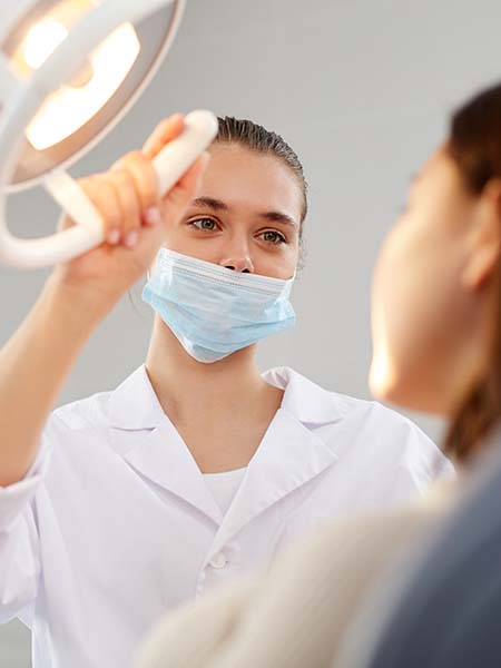 female-dentist-adjusting-lamp-dental-care-check-up-oral-health