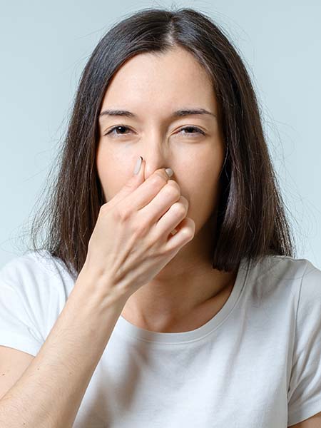 girl-covers-nose-with-hand-showing-that-something-stinks