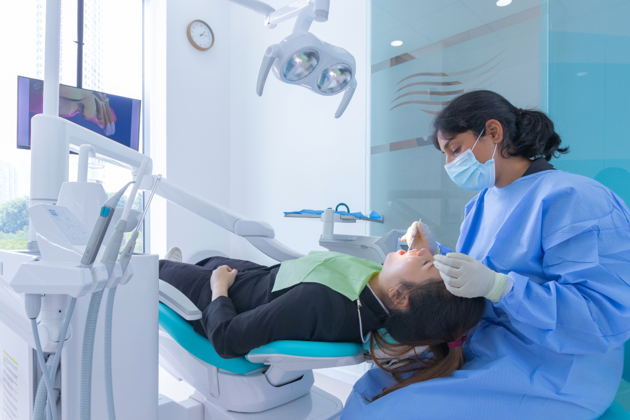 nuffield dental holland village - woman getting her teeth inspected by a dentisit